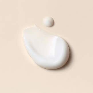 Close-up of white lotion or cream on a beige background